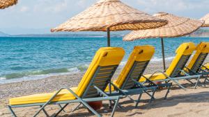 a group of chairs and umbrellas on a beach at Sundia Exclusive By Liberty Fethiye Adults Only in Fethiye