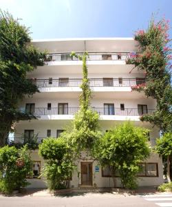 an apartment building with trees in front of it at Hostal Manolita in San Antonio