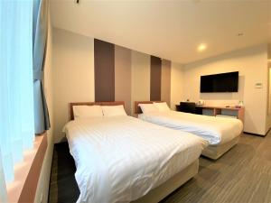Un pat sau paturi într-o cameră la Hotel Tetora