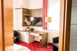 Camera d'albergo con scrivania e TV di Hotel Goldner Anker a Bad Elster