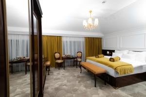 a bedroom with a large bed and a dining room at Hotel Integra Banja Luka in Banja Luka