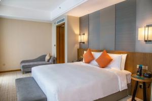 una habitación de hotel con una cama grande y una silla en InterContinental Sancha Lake, an IHG Hotel en Chengdú