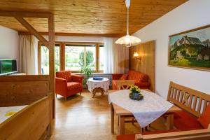 ein Wohnzimmer mit einem Tisch und einem Sofa in der Unterkunft Ferienwohnungen Plenk in Ruhpolding