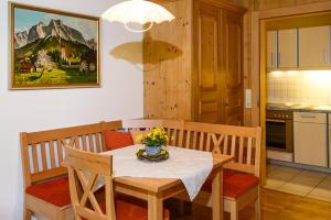 a kitchen with a dining room table with a white table cloth at Ferienwohnungen Plenk inkl. Chiemgaukarte in Ruhpolding