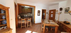 a kitchen with wooden cabinets and a table and chairs at IMEDA APARTAMENTO ENEBRO in Sierra Nevada