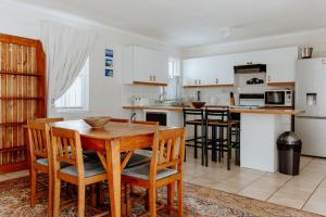 a kitchen with a wooden table and chairs at In Betwix in Paternoster +15 photos