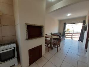 a kitchen with a stove and a table with chairs at Residencial Las Dunas in Florianópolis