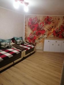 una habitación con 2 camas y una pared con flores en Гостинний двір у Ангеліни en Tatariv