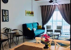 uma sala de estar com um sofá azul e mesas em Emira Residence Sek 13 Shah Alam Wi-Fi Netflix em Shah Alam