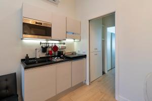 a kitchen with white cabinets and a sink at Scarlatti Luxury apt. - B. Aires / Central Station in Milan