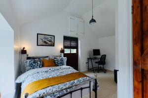 une chambre avec un lit et un bureau dans l'établissement Parc Farm Cottage, Flintshire, North Wales, à Rhydymwyn