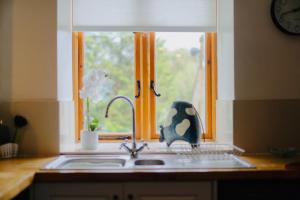 d'un évier de cuisine avec une fenêtre et d'une kitchenette. dans l'établissement Parc Farm Cottage, Flintshire, North Wales, à Rhydymwyn 44 autres photos