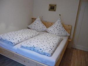 Una cama con dos almohadas encima. en Meistereders Ferienwohnung en Schönau am Königssee