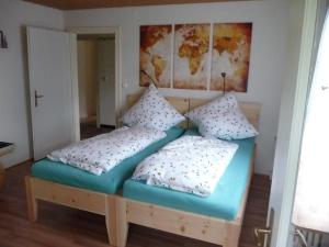 un lit dans une chambre avec deux oreillers dessus dans l'établissement Meistereders Ferienwohnung, à Schönau am Königssee