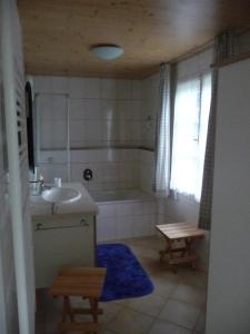 une salle de bain avec une baignoire et un lavabo et une baignoire dans l'établissement Meistereders Ferienwohnung, à Schönau am Königssee