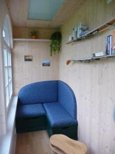 - un canapé bleu dans une chambre avec un mur dans l'établissement Meistereders Ferienwohnung, à Schönau am Königssee
