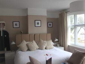 a bedroom with a large white bed with a window at The Red House Guest House in Falmouth