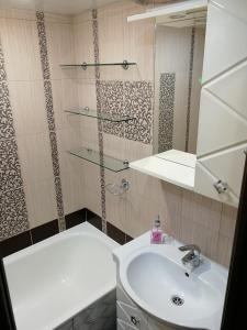 a bathroom with a sink and a mirror at "СКомфортом" однокомнатная квартира на Проспекте Мира 375 in Yuzhno-Sakhalinsk