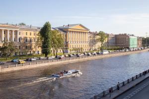 Una barca che percorre un fiume in una città di Hotel Golden Age a San Pietroburgo