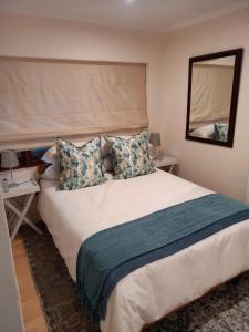 a bedroom with a large white bed with a mirror at Stunning BnB in Gorgeous Garden Setting in Germiston +17 photos