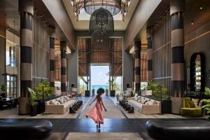 Una donna che cammina nella hall di un hotel di LUX* Grand Baie Resort & Residences a Grand Baie