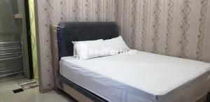 Bett mit schwarzem Kopfteil und weißen Kissen in der Unterkunft Homestay MM Syariah RedPartner in Sidoarjo