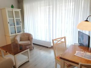 ヴェスターラントにあるSylter-Besserburg-App-2のリビングルーム(ソファ、椅子、テレビ付)