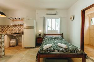 - une cuisine avec un lit et un réfrigérateur dans la chambre dans l'établissement Marília EcoHome Pipa, à Pipa