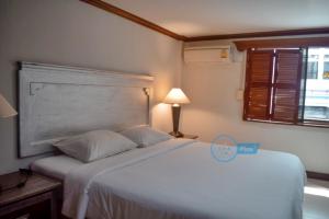 巴東海灘的住宿－丹戎旅館，卧室配有白色的床和窗户。