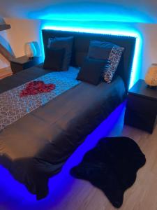 a bed in a room with a blue light at Agréable maisonnette de ville avec jacuzzi in Béthisy-Saint-Martin