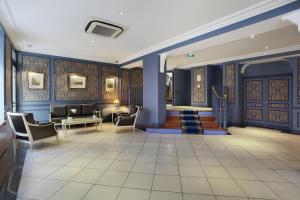 un vestíbulo con paredes y sillas azules y una escalera en HOTEL DU PRINTEMPS en París