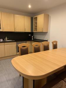 cocina con mesa de madera y algunas sillas en Monteurzimmer Oberlistingen Zweibettzimmer mit 2 Bädern, en Breuna