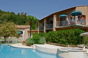 a resort with people on the balcony with umbrellas at Les Hauts De Greoux in Gréoux-les-Bains