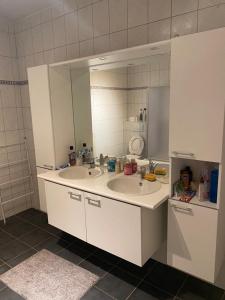 a bathroom with two sinks and a large mirror at 10mins from Brussels Airport 2 rooms living room and Patio in Zaventem
