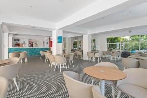 a dining room with tables and chairs and windows at BLUESEA Piscis - Adults Only in Port d'Alcudia