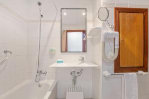a white bathroom with a sink and a mirror at BLUESEA Piscis - Adults Only in Port d'Alcudia