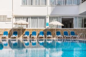a group of blue chairs and a swimming pool at BLUESEA Piscis - Adults Only in Port d'Alcudia
