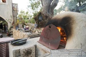 een pizzaoven met een vuur erin bij Villa Anta house by the sea in Lithakia