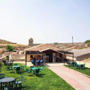 a building with tables and chairs in the grass at Santa Brigida - Real 1 in Hontanas