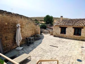 a patio with chairs and an umbrella next to a building at Santa Brigida - Real 1 in Hontanas