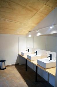 a bathroom with three sinks and a mirror at Santa Brigida - Real 1 in Hontanas