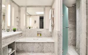 a bathroom with a tub and a sink and a mirror at Rosewood Villa Magna in Madrid