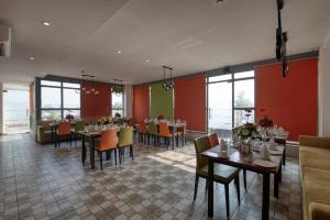 a dining room with tables and chairs and windows at Hotel Deep Clarks Inn Lucknow in Lucknow