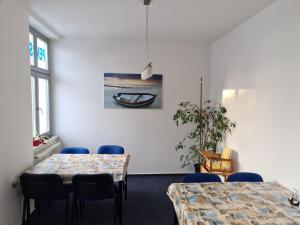 a meeting room with two tables and blue chairs at Hanse Haus Pension in Greifswald