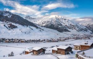 een stad in de sneeuw met een besneeuwde berg bij Viola in Livigno