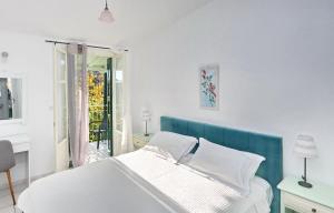 a white bedroom with a bed and a balcony at Pelagos in Stafylos