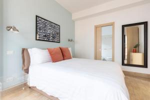 a bedroom with a large white bed and a mirror at AlbaRoma Apartment in Rome