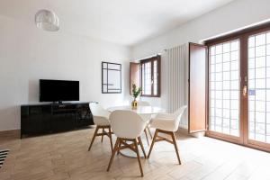 a dining room with a table and chairs and a tv at AlbaRoma Apartment in Rome