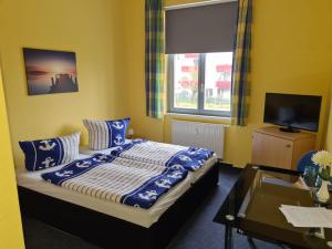 a bedroom with a bed with blue pillows and a window at Hanse Haus Pension in Greifswald
