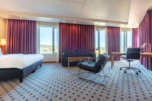 a hotel room with a bed and a desk and chairs at Radisson Blu Hotel Oslo Alna in Oslo